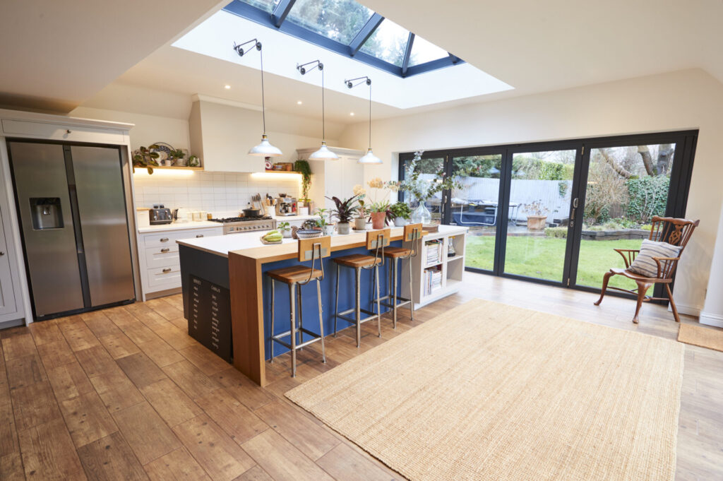 Interior View Of Beautiful Kitchen With Island Counter And Table For Children In New Family House